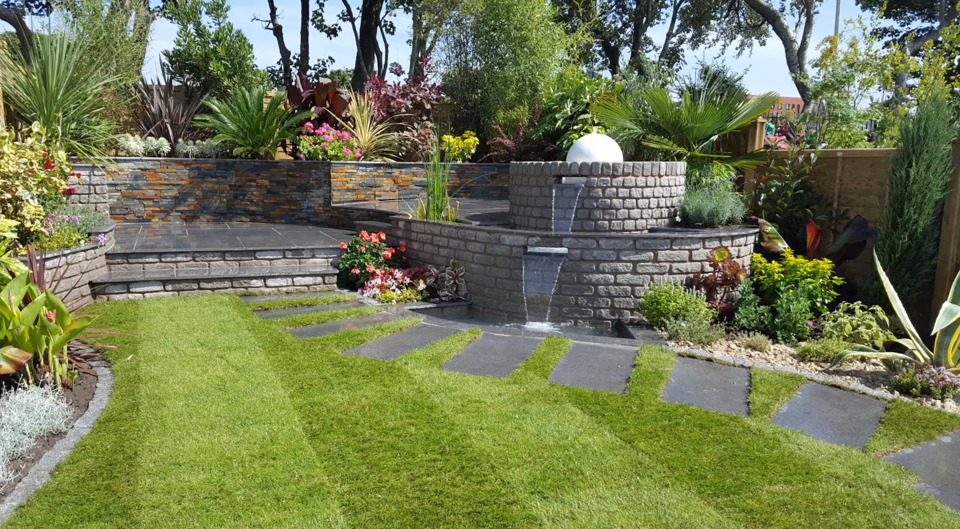 Rose Gardens landscaped garden with tiered stonework, lawn, paving and established planting